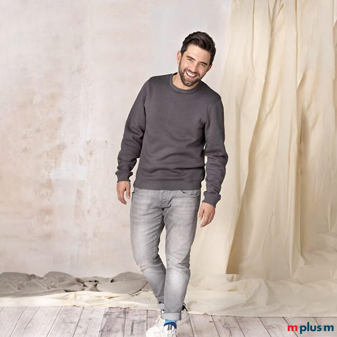 Model trägt graues nachhaltiges Sweatshirt. Individuell mit Logo zu bedrucken