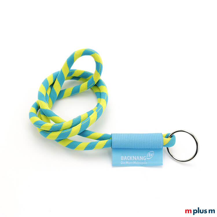 Schlüsselband in Tube Kordelausführung, zweifarbig gewebt und mit dem Logo auf fest vernähtem Textil Etikett. Mit Schlüsselring.